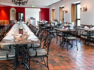 a dining room with long tables and chairs at DORMERO Hotel Stuttgart in Stuttgart