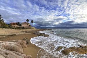 een strand met rotsen en een huis en de oceaan bij T2 Terrasse Vue Mer - Route des Sanguinaires in Ajaccio