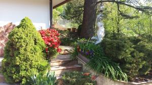 un jardín con flores y una estatua y un árbol en B&B Al Cedro, en Sporminore