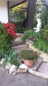 un jardín con una estatua y algunas flores y plantas en B&B Al Cedro, en Sporminore