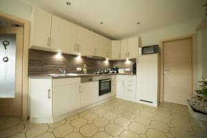 a kitchen with white cabinets and a stove top oven at Gästehaus Marichen in Aurich