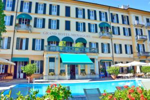 un hotel con piscina di fronte a un edificio di Grand Hotel Menaggio a Menaggio