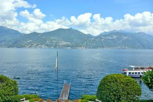 una barca in un grande bacino d'acqua con montagne di Grand Hotel Menaggio a Menaggio