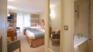 a hotel room with a bed and a bathroom at Marwell Hotel - A Bespoke Hotel in Winchester