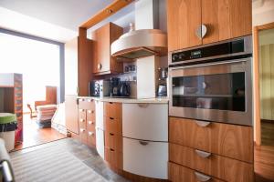 a kitchen with wooden cabinets and a stove top oven at Papli Villa in Pärnu