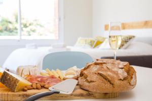 um prato de comida com um pão e um copo de vinho em Rambla de Marisol Apartments em Castelldefels