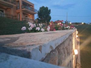 un mur de rétention avec des fleurs devant un bâtiment dans l'établissement Finiki Plaza, à Methoni