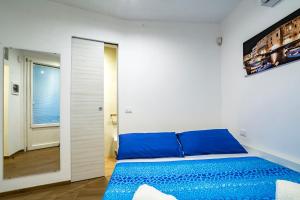 een slaapkamer met een blauw bed en een raam bij Casa Damare Capitolo in Monopoli