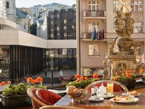 uma mesa com pratos de comida no topo de um edifício em Hotel Romance em Karlovy Vary