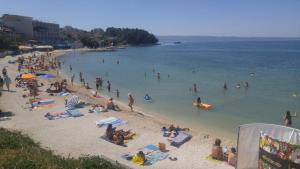 um grupo de pessoas em uma praia na água em Apartment Sano em Podstrana