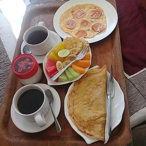 einen Tisch mit zwei Teller Essen und zwei Tassen Kaffee in der Unterkunft Padangbai Beach inn in Padangbai