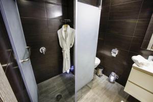 a bathroom with a shower with a robe hanging on the wall at Calypso Home Oran in Oran