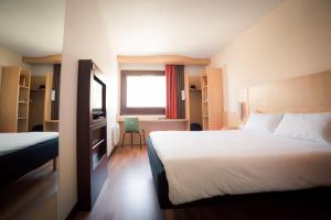 Habitación de hotel con cama y escritorio en ibis Grenoble Gare, en Grenoble