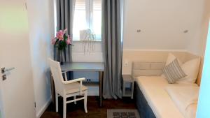 - une petite chambre avec un lit et un bureau avec une table dans l'établissement Hotel Stadt Soltau, à Soltau