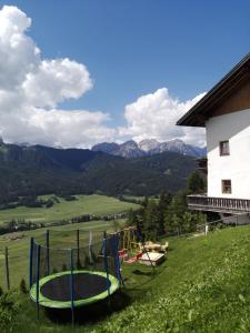 un parco giochi su una collina accanto a un edificio di Wegscheiderhof a Dobbiaco