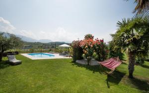 um jardim com uma rede de descanso e uma piscina em Villa Raifer em Appiano sulla Strada del Vino