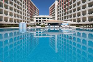 Ukino Palmeiras Village - 24h All Inclusive في أرماساو دي بيرا: مسبح كبير مقابل مبنيين