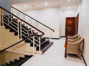 - un escalier dans un bâtiment avec deux chaises et une porte dans l'établissement RedDoorz Plus @ Grand City Inn, à Makassar