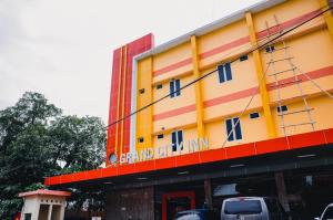 un bâtiment coloré avec des voitures garées devant lui dans l'établissement RedDoorz Plus @ Grand City Inn, à Makassar