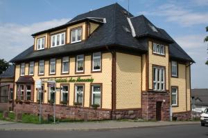 um grande edifício de tijolos com um telhado preto em Pension Haus Saarland em Oberhof