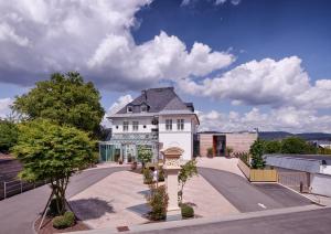 a large white building with a black roof at Hotel Villa Hügel in Trier