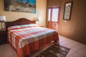 Schlafzimmer mit einem Bett, einem Fenster und einer Tür in der Unterkunft La Cupula B&B Teotitlan in Teotitlán del Valle