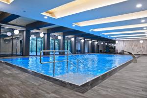 ein großer Pool mit blauem Wasser in einem Gebäude in der Unterkunft Hotel SPA Budowlani in Szczawnica