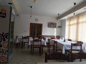 een eetkamer met tafels en stoelen en een klok aan de muur bij Chata Holica PIENINY in Lesnica