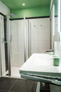 a bathroom with a shower and a white sink at Altstadt-Apartment in Freiberg