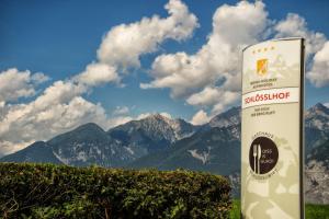 un panneau devant une chaîne de montagnes avec des nuages dans l'établissement MONDI Hotel Axams, à Innsbruck