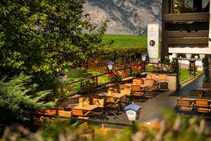 une rangée de tables et de chaises dans un restaurant dans l'établissement MONDI Hotel Axams, à Innsbruck