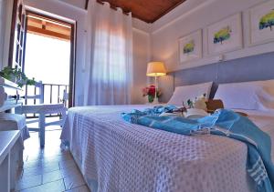 a bedroom with a white bed with a table and a window at Boutique Hotel Kentrikon & Bungalows in Agios Ioannis Pelio