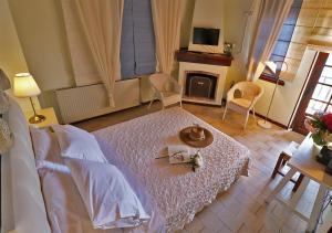 a bedroom with a bed with a table and a fireplace at Boutique Hotel Kentrikon & Bungalows in Agios Ioannis Pelio