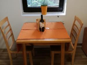 een houten tafel met een fles wijn erop bij Apartments Jelka in Kranjska Gora