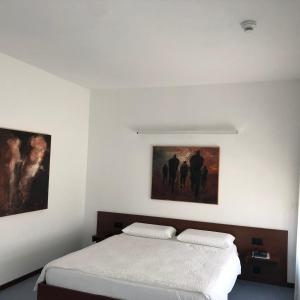 a bedroom with a bed and a painting on the wall at Hotel Ceresio in Lugano