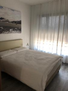 a bedroom with a white bed and a window at Hotel Ceresio in Lugano