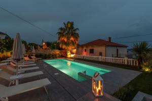 une piscine avec des chaises longues et une maison dans l'établissement Villa Ana Trogir, à Trogir