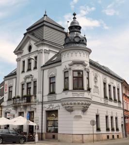 a white building with a tower on top of it at Olymp penzion in Komárno