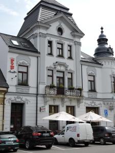 a white building with a van parked in front of it at Olymp penzion in Komárno