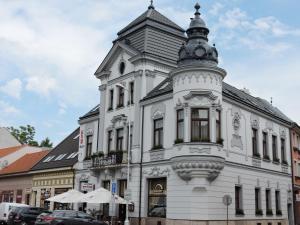 a white building with a tower on top of it at Olymp penzion in Komárno