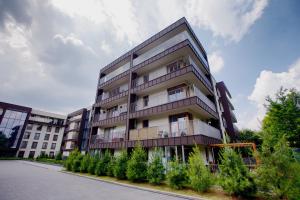 a tall apartment building with trees in front of it at Apartament "Park Lotników" in Kraków