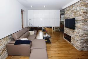 a living room with a couch and a stone wall at Apartament "Park Lotników" in Kraków