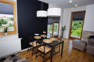 a black dining room with a table and chairs at Apartament "Park Lotników" in Kraków