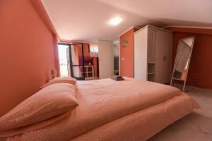 a bedroom with a large bed with an orange blanket at 32 in Ciampino