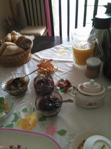 una mesa cubierta con tazones de comida y una cesta de pan en Quinta Nova do Almeida, en Alcobaça