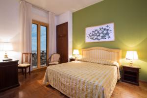 ein Hotelzimmer mit einem Bett und einem Balkon in der Unterkunft Hotel Isabella in Taormina