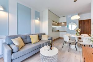 een woonkamer met een bank en een tafel bij GRANO APARTMENTS Gdańsk Nowa Motława SPA & Wellness in Gdańsk