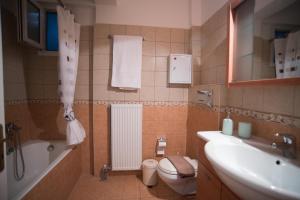 a bathroom with a sink and a toilet and a tub at Mary's House in Lefkada Town