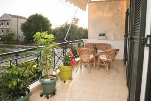 a balcony with a table and chairs and potted plants at Mary's House in Lefkada Town