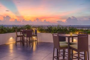 a patio with tables and chairs and a sunset at Jetwing Jaffna in Jaffna